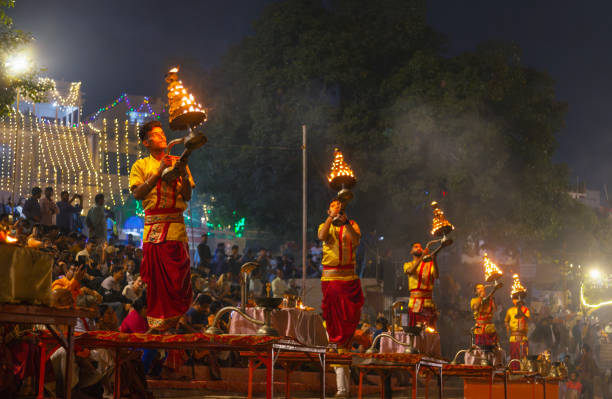 Varanasi, India - November 21, 2023: Crowds gathered to watch the evening Aarti Ceremony on the banks of the River Ganges; a Hindu ceremony in which pajuris  (attendants to the deities) perform a ritual with lighted wicks soaked in ghee and offered up to one or more deities.